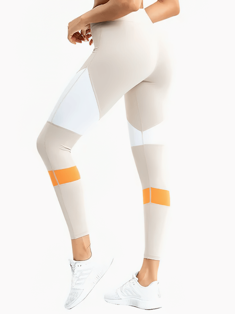 Woman wearing stylish high-waisted leggings with vibrant accents, perfect for yoga, running, or gym sessions, showcasing a sleek look.
