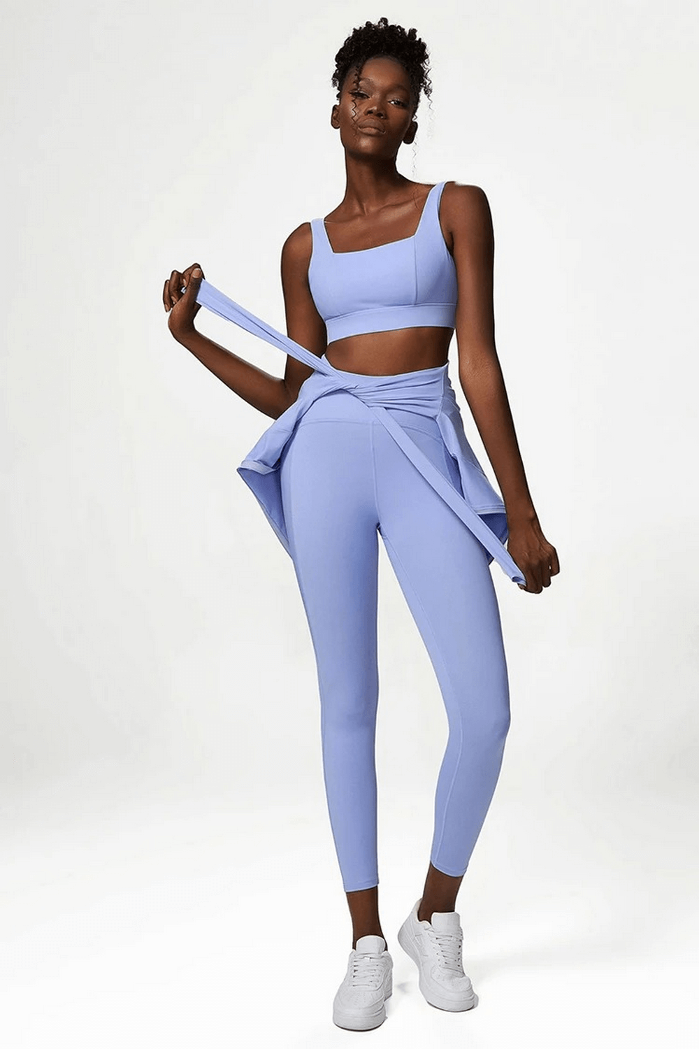 Model wearing light blue women's nylon-spandex yoga leggings with matching sports bra, showcasing a stylish and comfortable activewear set.