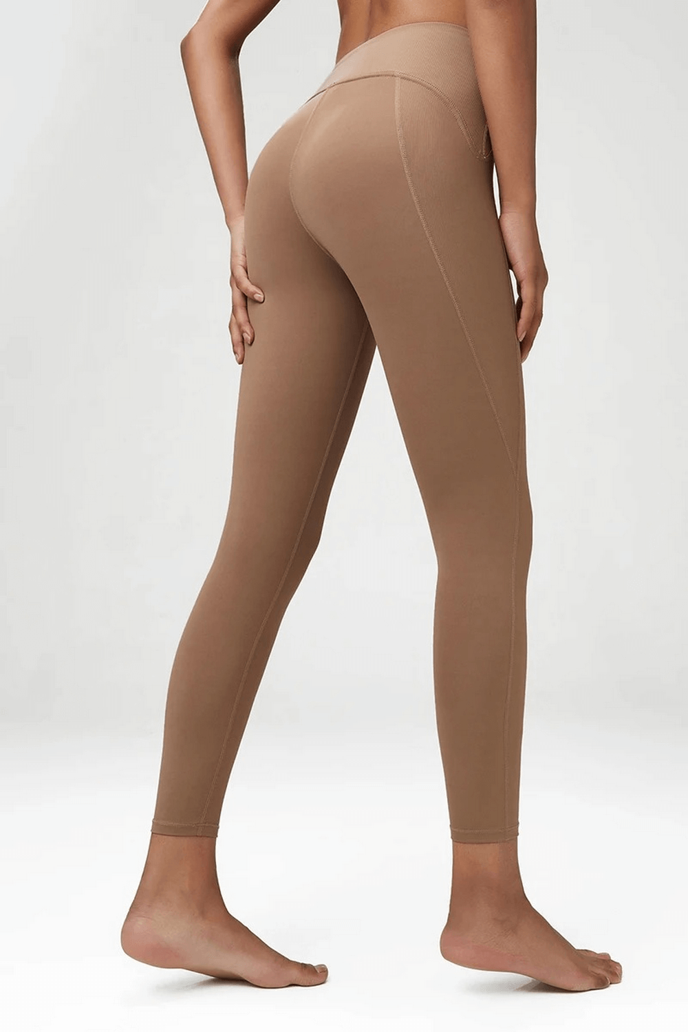 Back view of woman wearing beige yoga and gym stretch leggings SF2100, showcasing snug fit and elastic waistband.