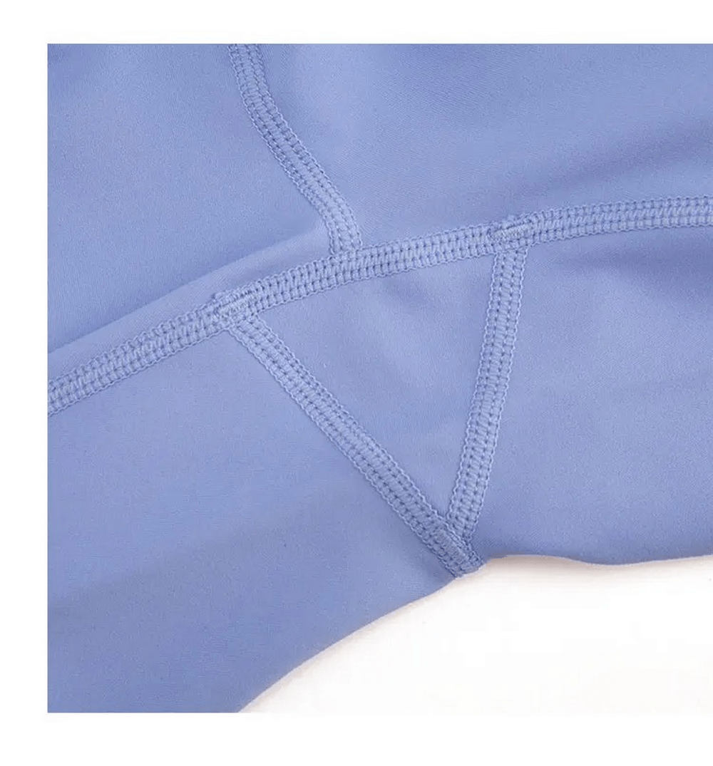 Close-up of light blue nylon-spandex women's leggings showing durable stitching and quality fabric suitable for yoga and gym activities.