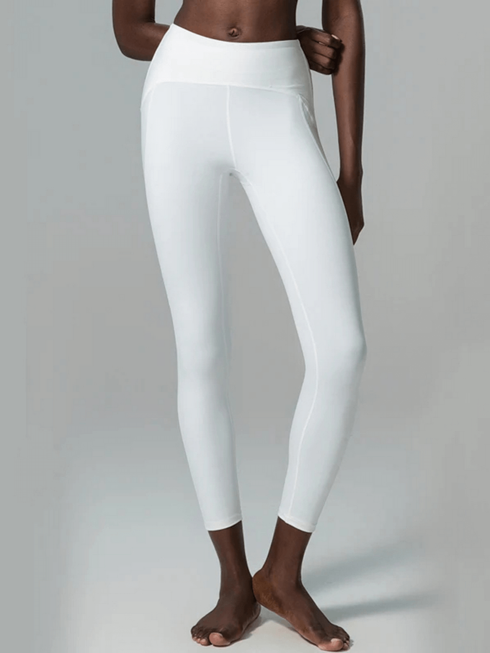 Women's white yoga and gym leggings with a high waistband in nylon-spandex blend, perfect for versatile sports activities.