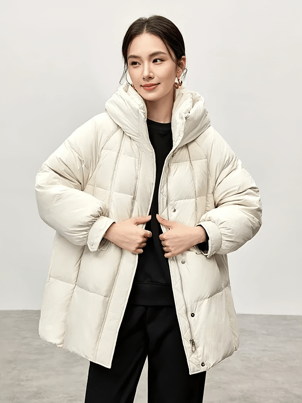 Woman wearing a white hooded duck down puffer jacket with stand neck. Warm nylon winter coat with zipper and buttons, model SF2309.