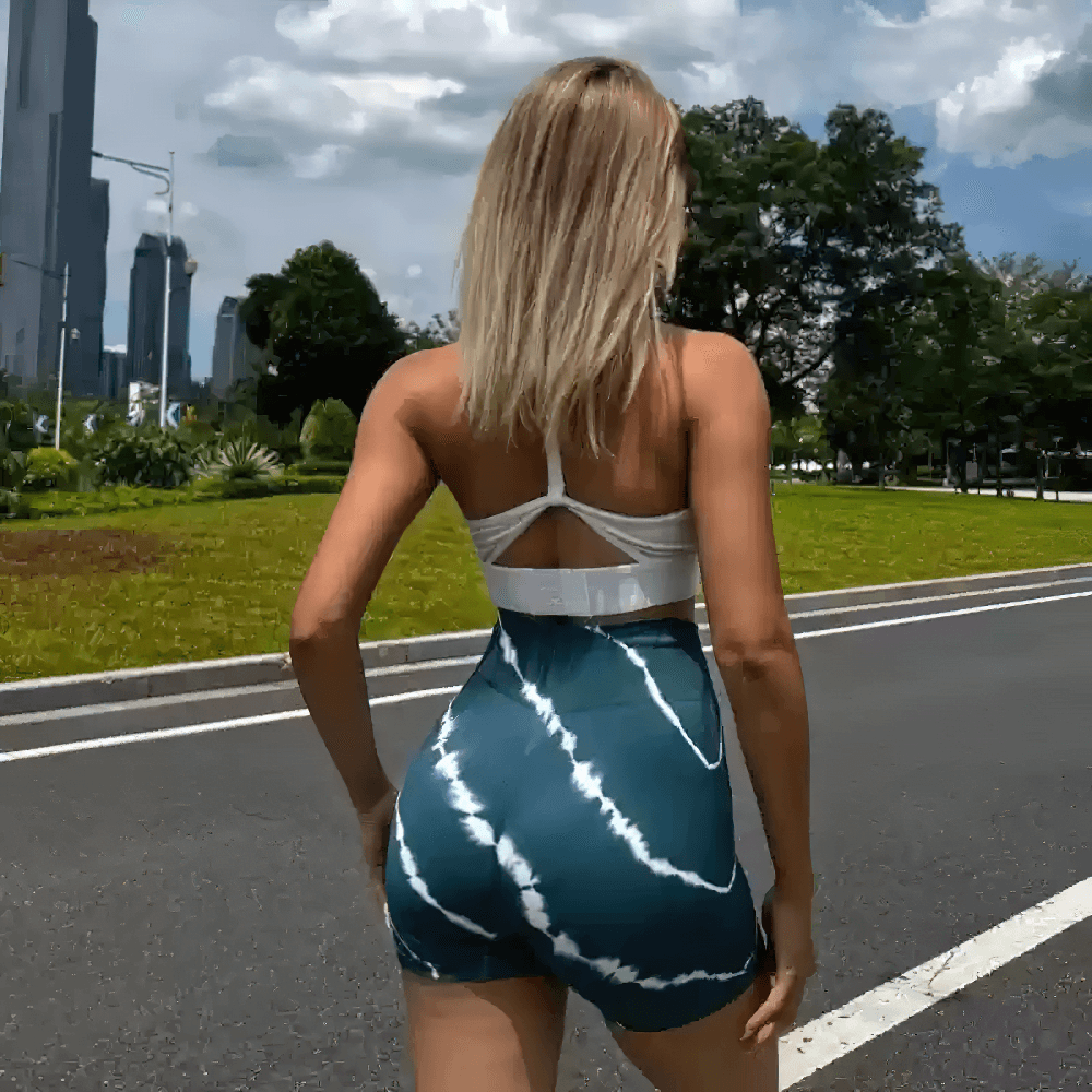 Woman wearing Women's Tie-Dye High Waist Peach Lift Shorts - SF4127 in a park setting, showcasing the seamless fit and stylish design.