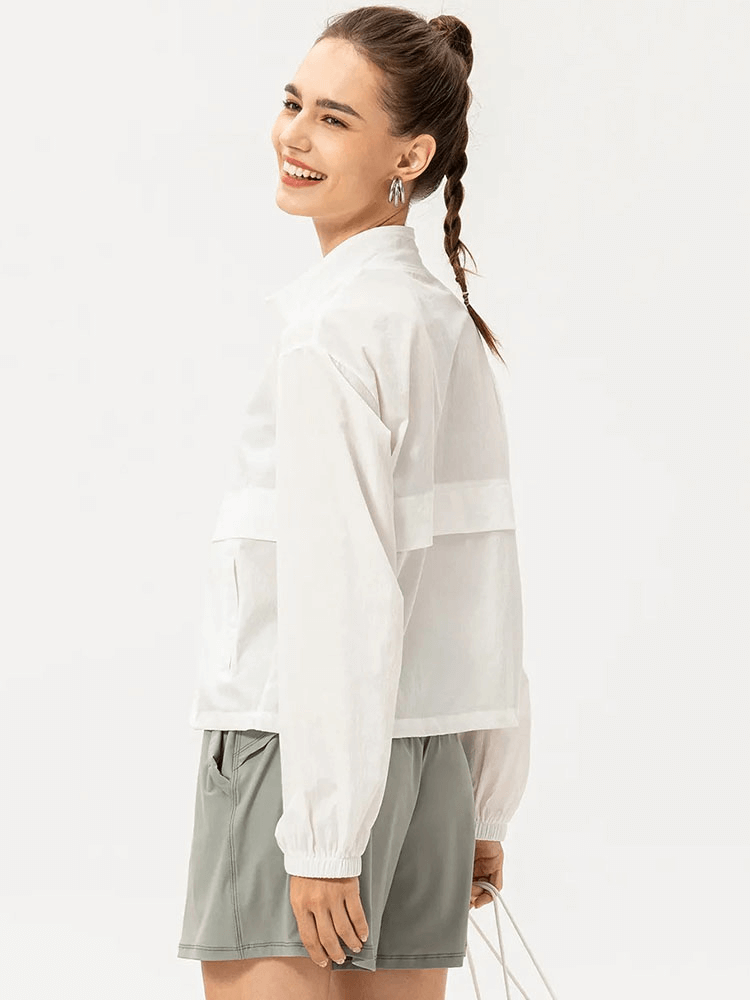 Woman wearing a white UV protection running windbreaker, perfect for outdoor sports and featuring a stylish turn-down collar.