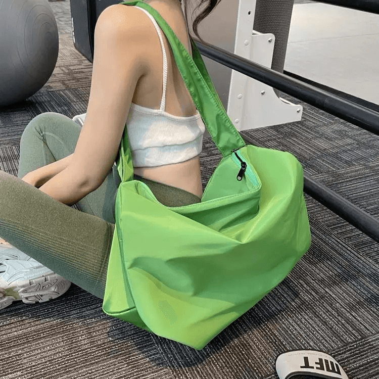 Women's green waterproof large-capacity fitness tote bag in a gym setting, perfect for workouts and storing your essentials securely.