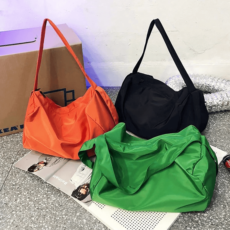 Bright orange, black, and green large-capacity fitness tote bags on display, perfect for waterproof storage and versatile style.