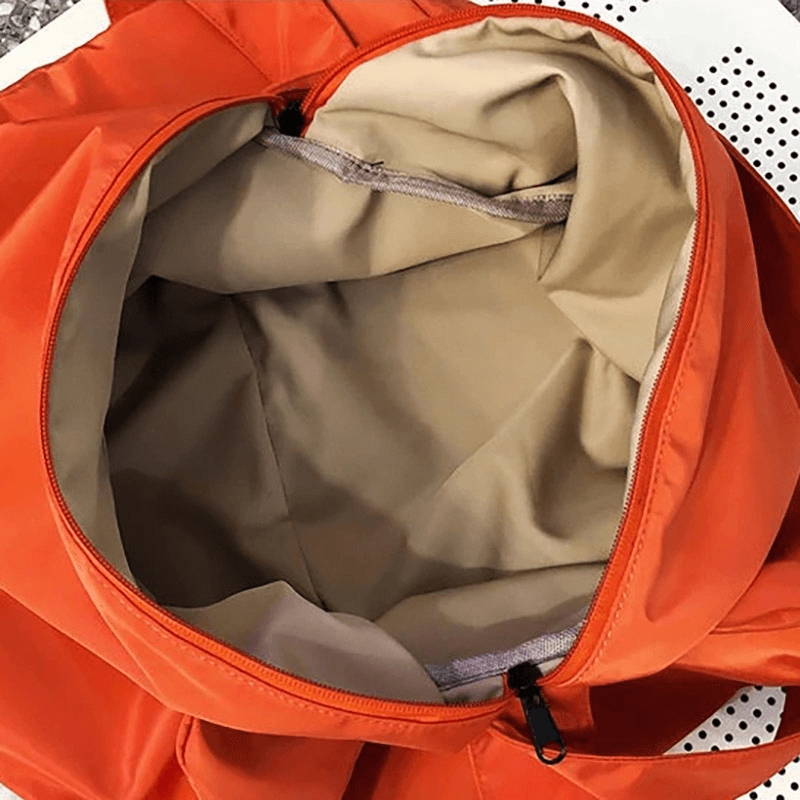 Open orange fitness tote bag showing spacious waterproof interior with zipper closure, perfect for workouts and travel.