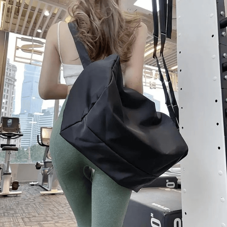 Woman at gym with waterproof large-capacity fitness tote bag, SF1993, in black. Perfect for securing workout gear.