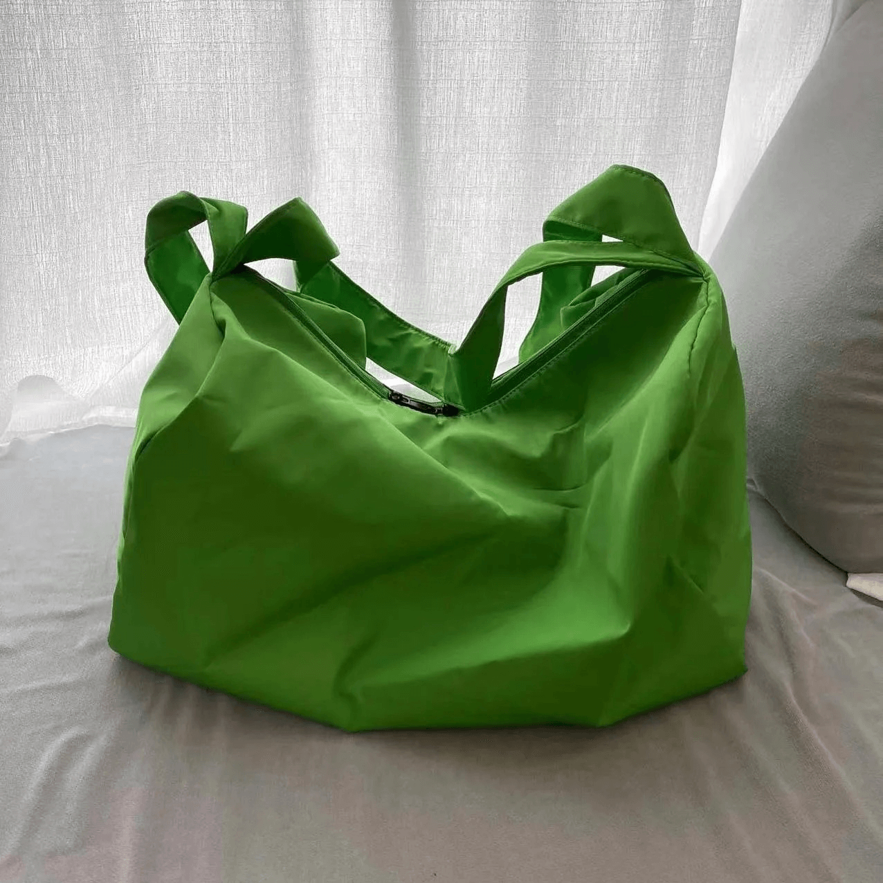 Bright green women's waterproof large-capacity fitness tote bag on bed, perfect for workouts, with durable design.
