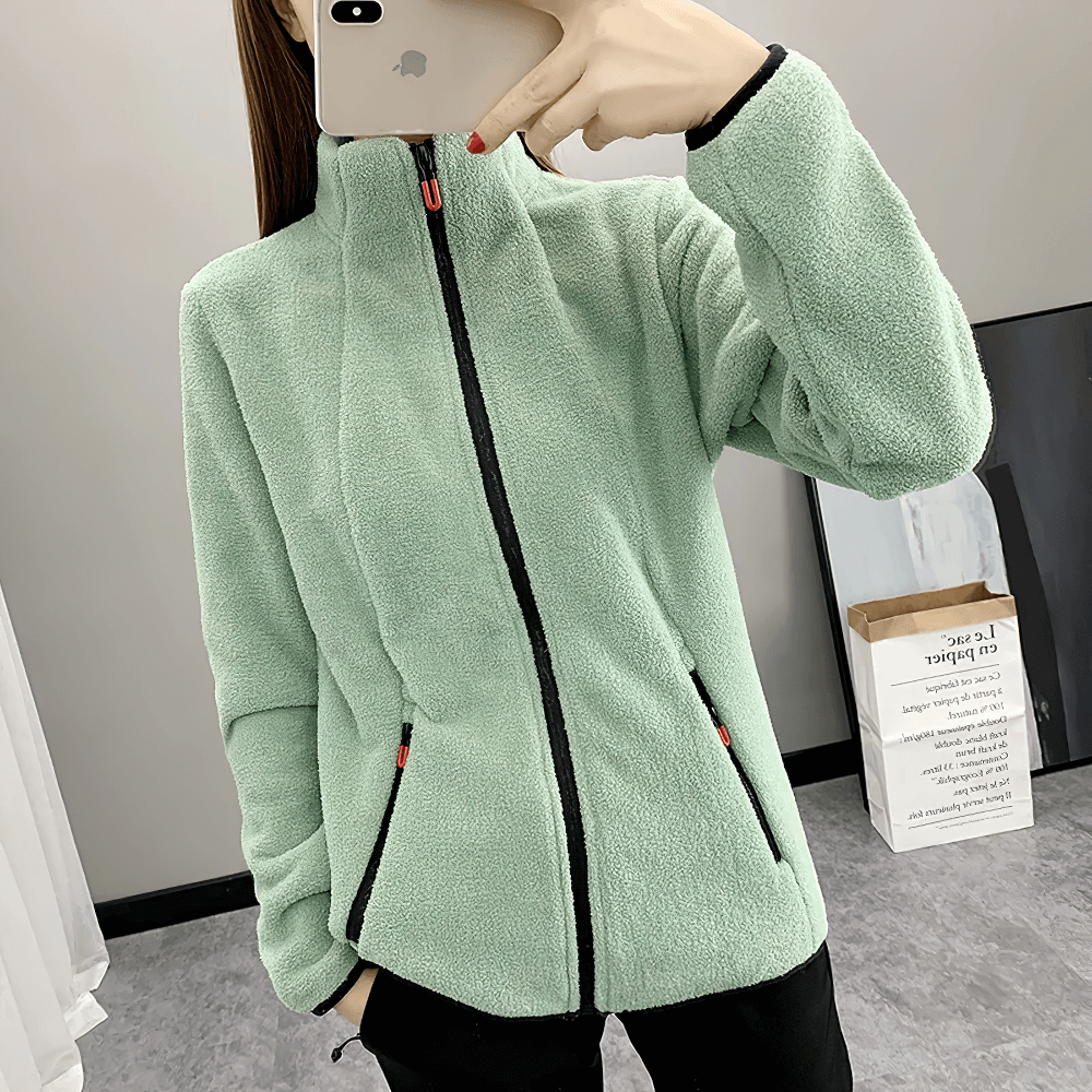 Woman wearing Women's Windproof Thermal Fleece Jacket for Hiking - SF4085, showcasing fleece texture and zip pockets indoors.