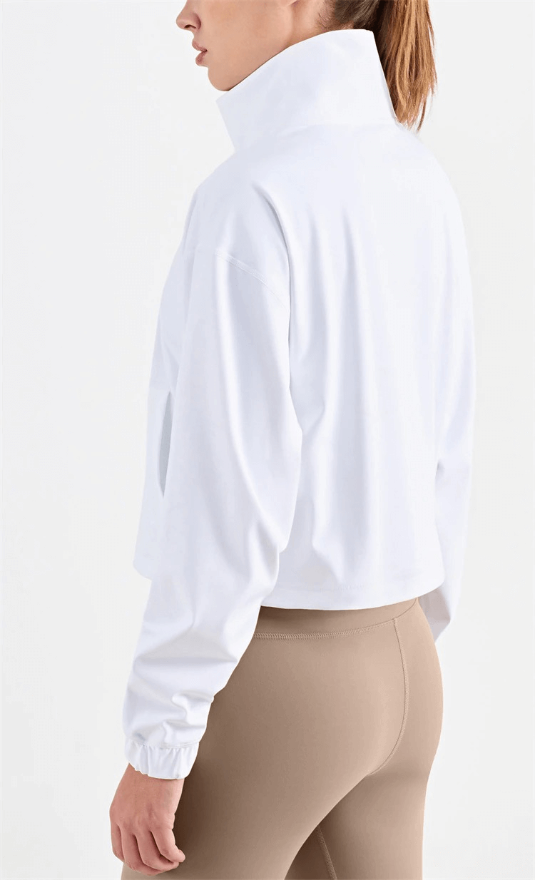 Woman wearing a white women's workout sports sweatshirt with a high collar and beige leggings, showcasing back and collar details.