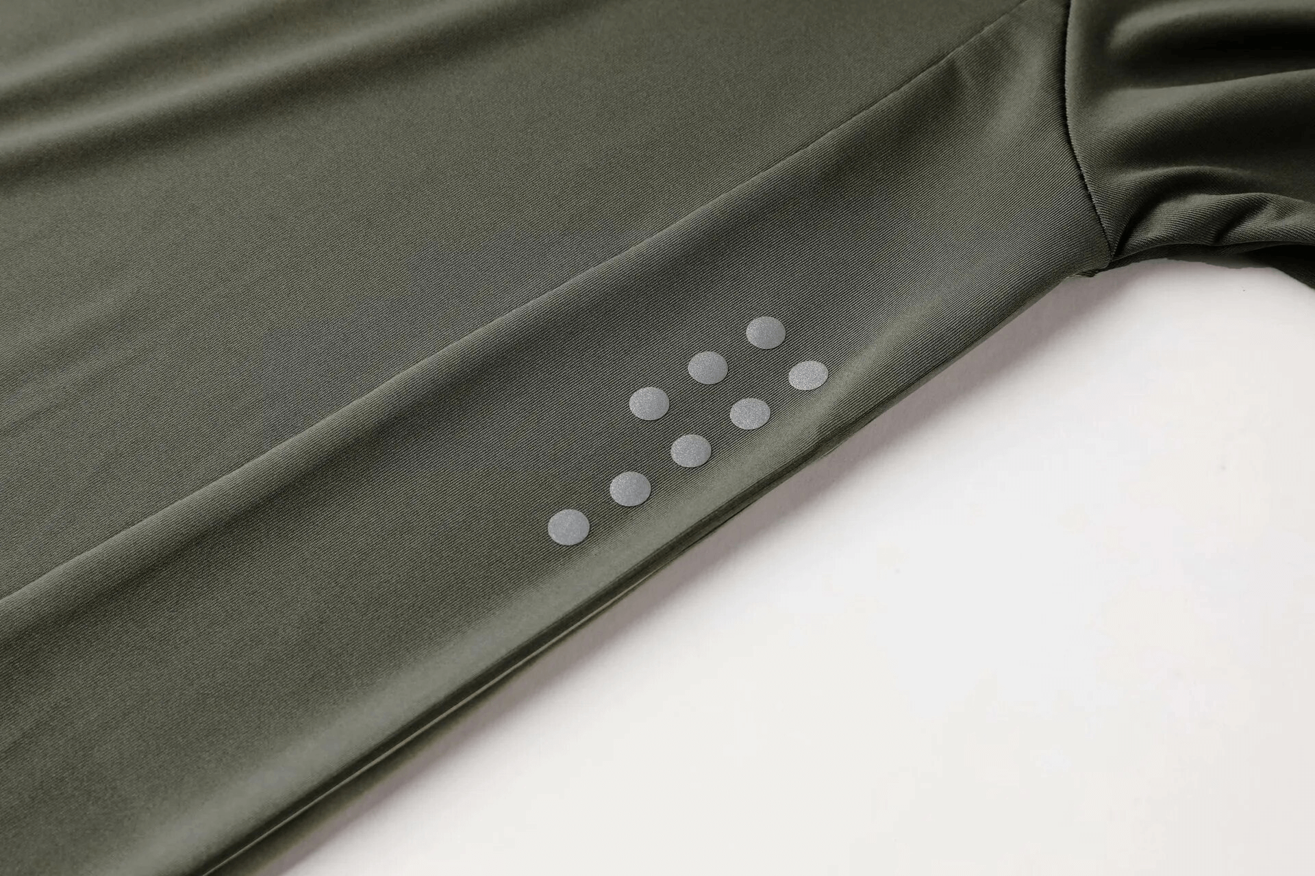 Close-up of a green workout long sleeve top for men, featuring a compression fit and dotted design on the sleeve.