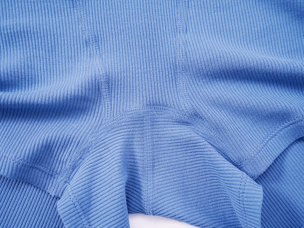Close-up of blue ribbed fabric on solid color women's yoga and fitness shorts, ideal for running and dance. Soft, stretchy, and snug fit.