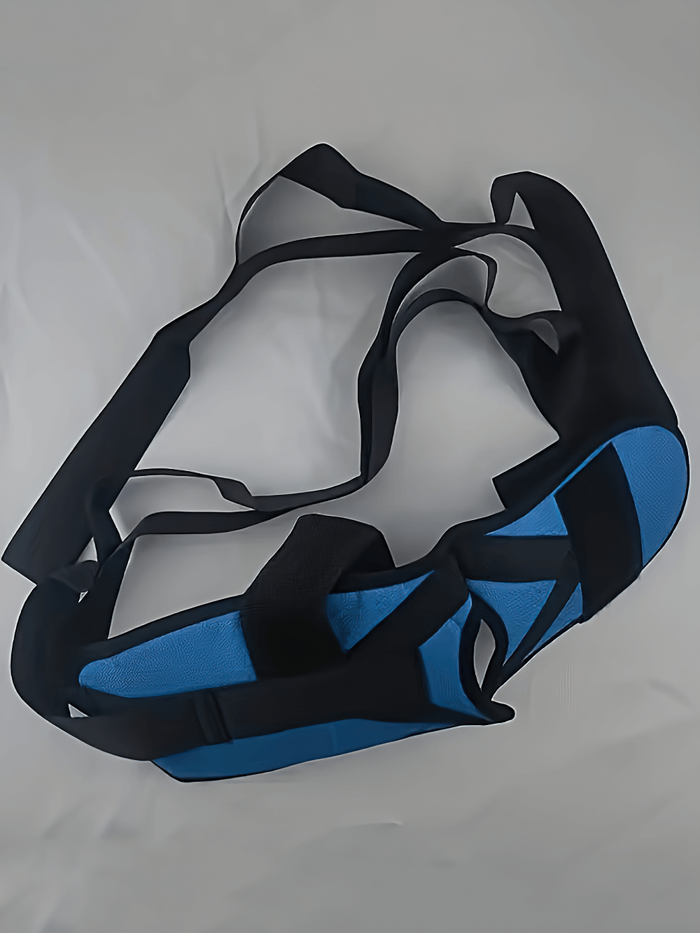 Blue yoga foot stretching strap with loops for flexibility and rehab training on a neutral background.