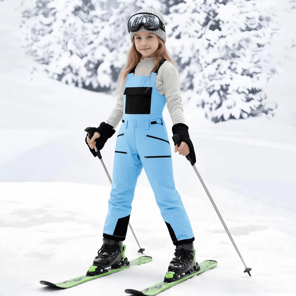 Young skier in Youth Waterproof Ski and Snowboarding Pants - SF3908, enjoying snowy mountains with insulated blue snowpants.