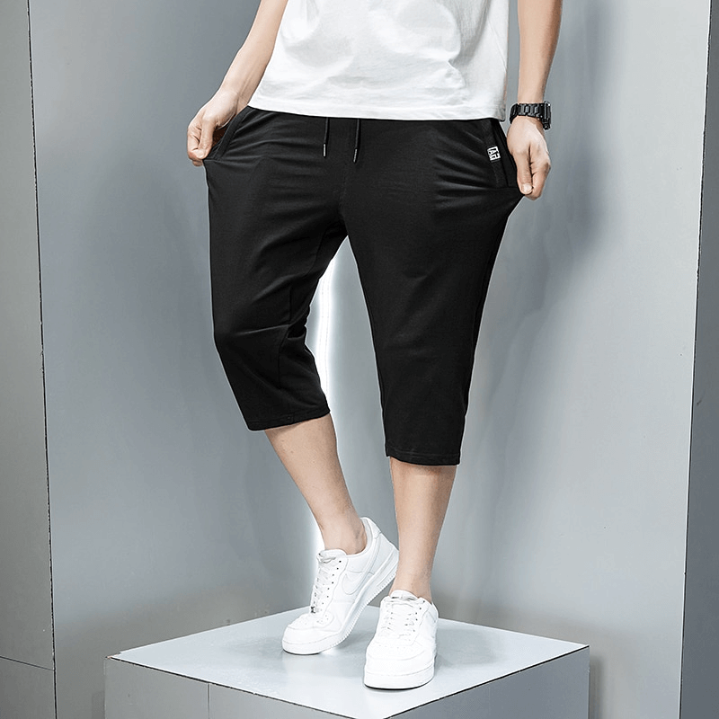 Casual men's black breeches with zip pockets and drawstring, showcasing breathable cotton fabric perfect for outdoor sportswear.