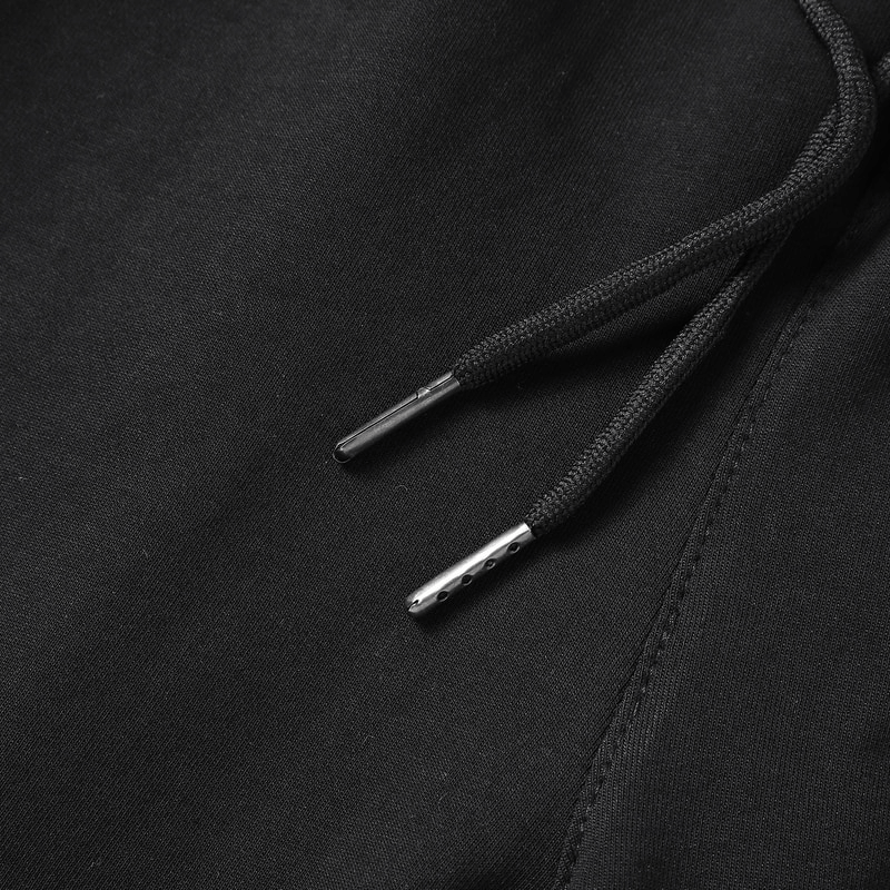 Close-up of drawstrings on black breathable cotton breeches, highlighting stitching detail and texture.