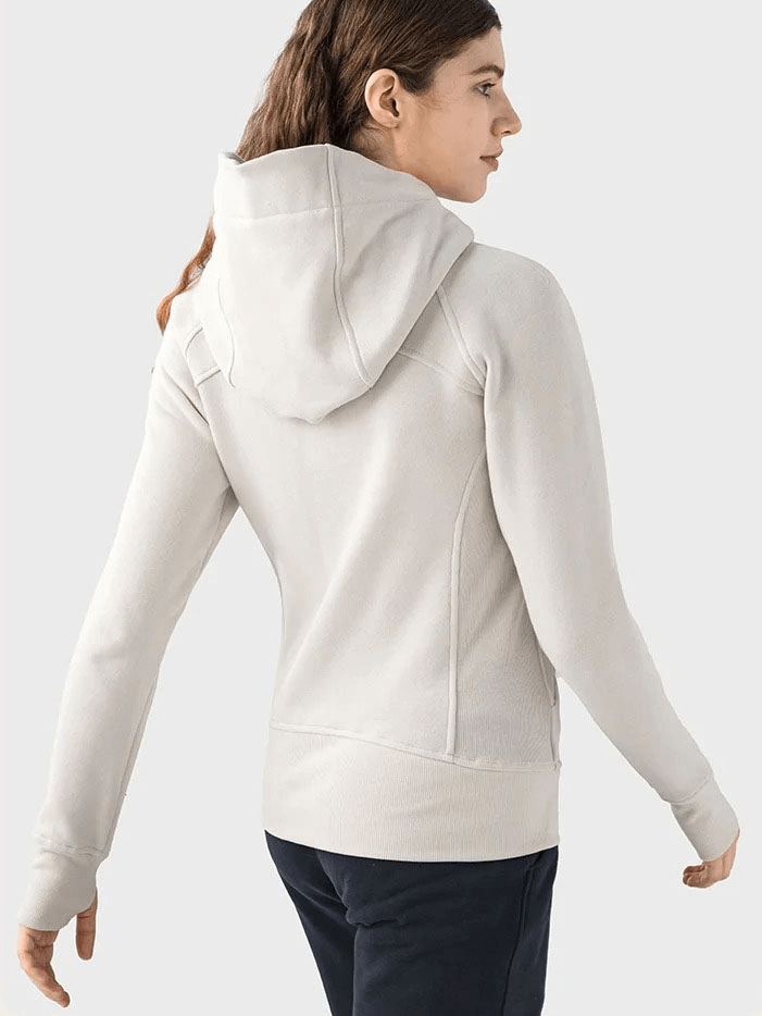 Woman wearing a beige zip-up athletic fleece hoodie with hood, perfect for warmth and comfort during activities.