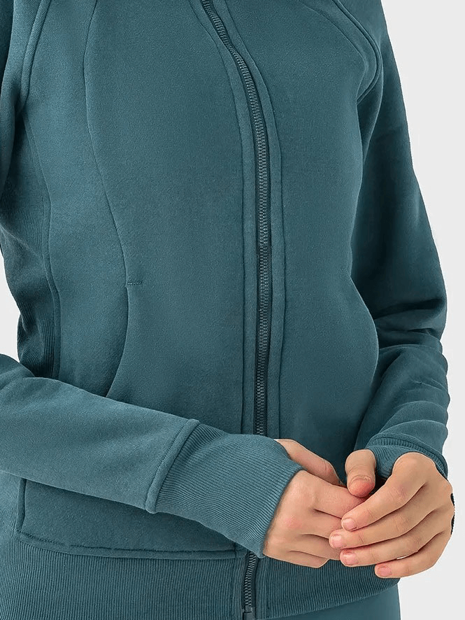 Close-up of a woman wearing a teal zip-up athletic fleece hoodie with full-length sleeves and a comfortable fit.