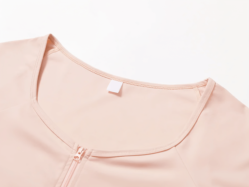 Close-up of blush pink zip-up long-sleeve yoga top with zipper detail, perfect for stylish and functional activewear.