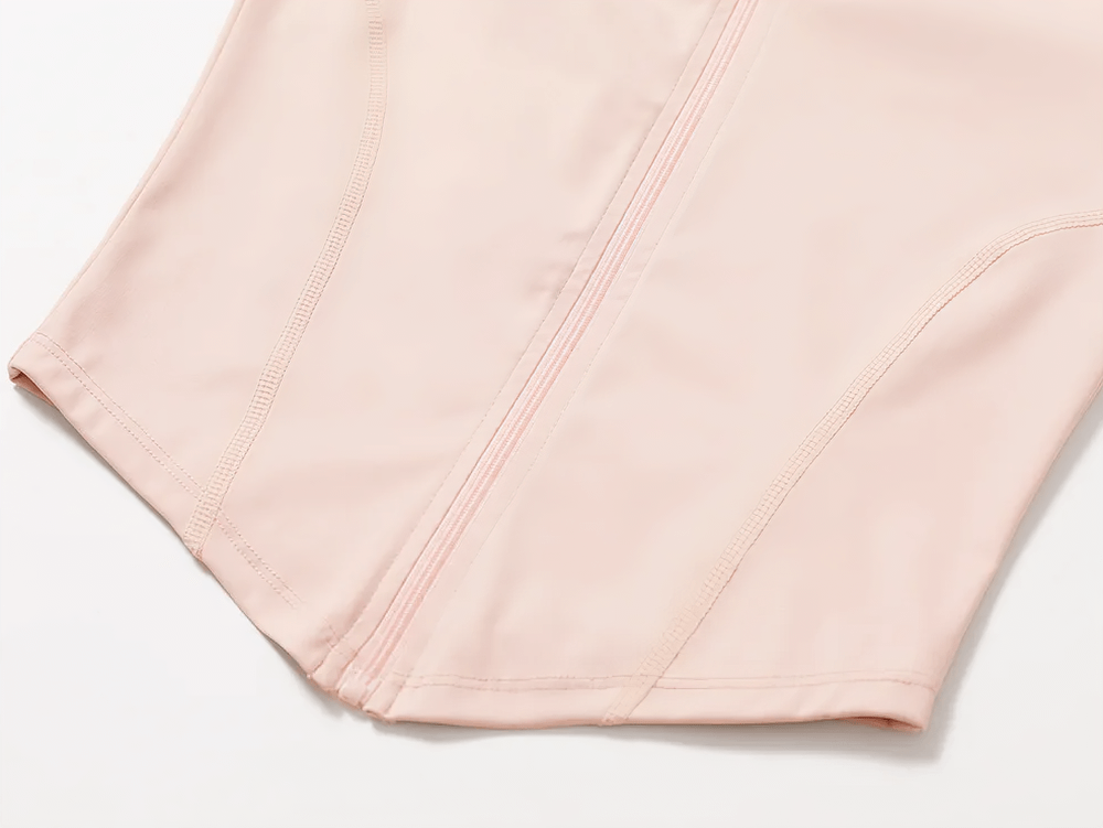 Close-up of a pink zip-up long-sleeved yoga top with sleek seams and quick-dry fabric.