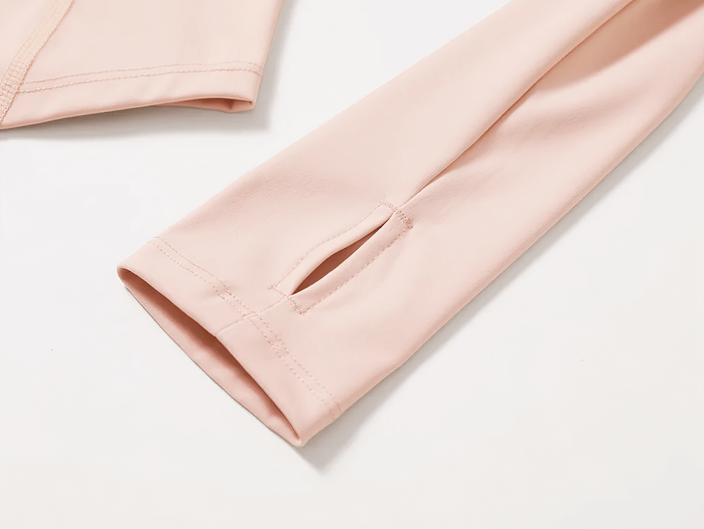 Close-up of a pink long-sleeve yoga top with thumbholes, showcasing sleek design and quick-dry fabric perfect for activewear.