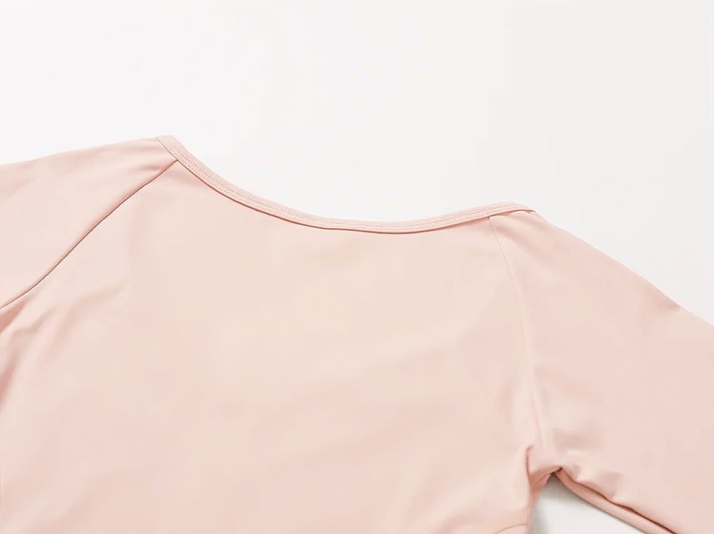 Sleek pink long-sleeved yoga top with smooth fabric detail, perfect for a stylish and functional workout look.