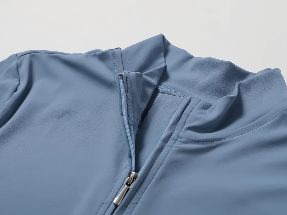 Close-up of blue zippered short-sleeve workout romper showcasing sleek design and comfortable stretch fabric for activewear.