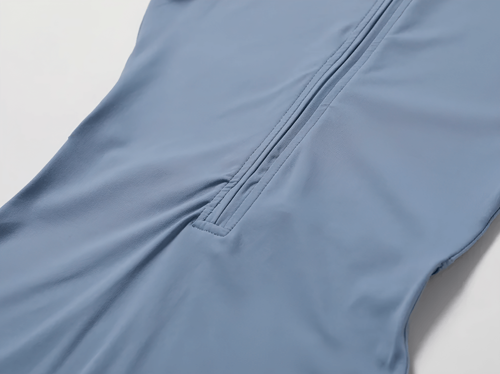 Close-up of a zippered front on a blue short-sleeved workout romper, showcasing sleek design and stretch fabric for women’s activewear.