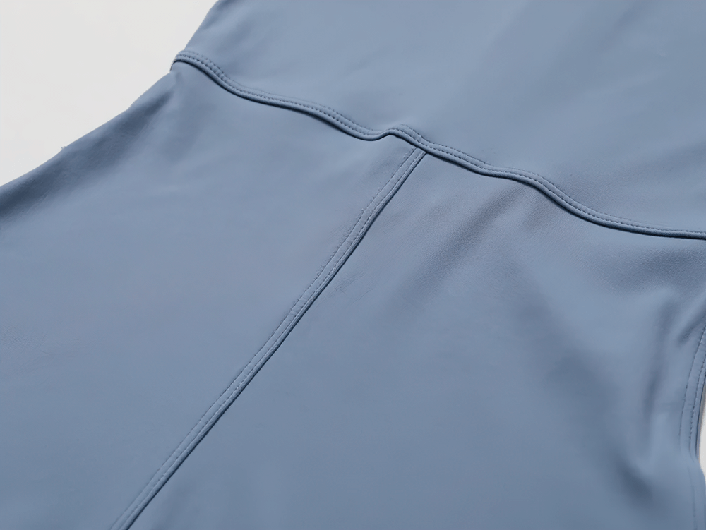 Close-up of a blue zippered short-sleeved workout romper showing sleek fabric and stitch detailing.