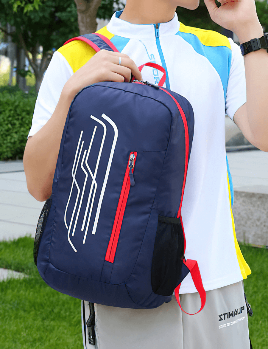 Cyclist holding 22L portable folding ultralight cycling backpack in navy, with red and white accents, ideal for outdoor adventures.