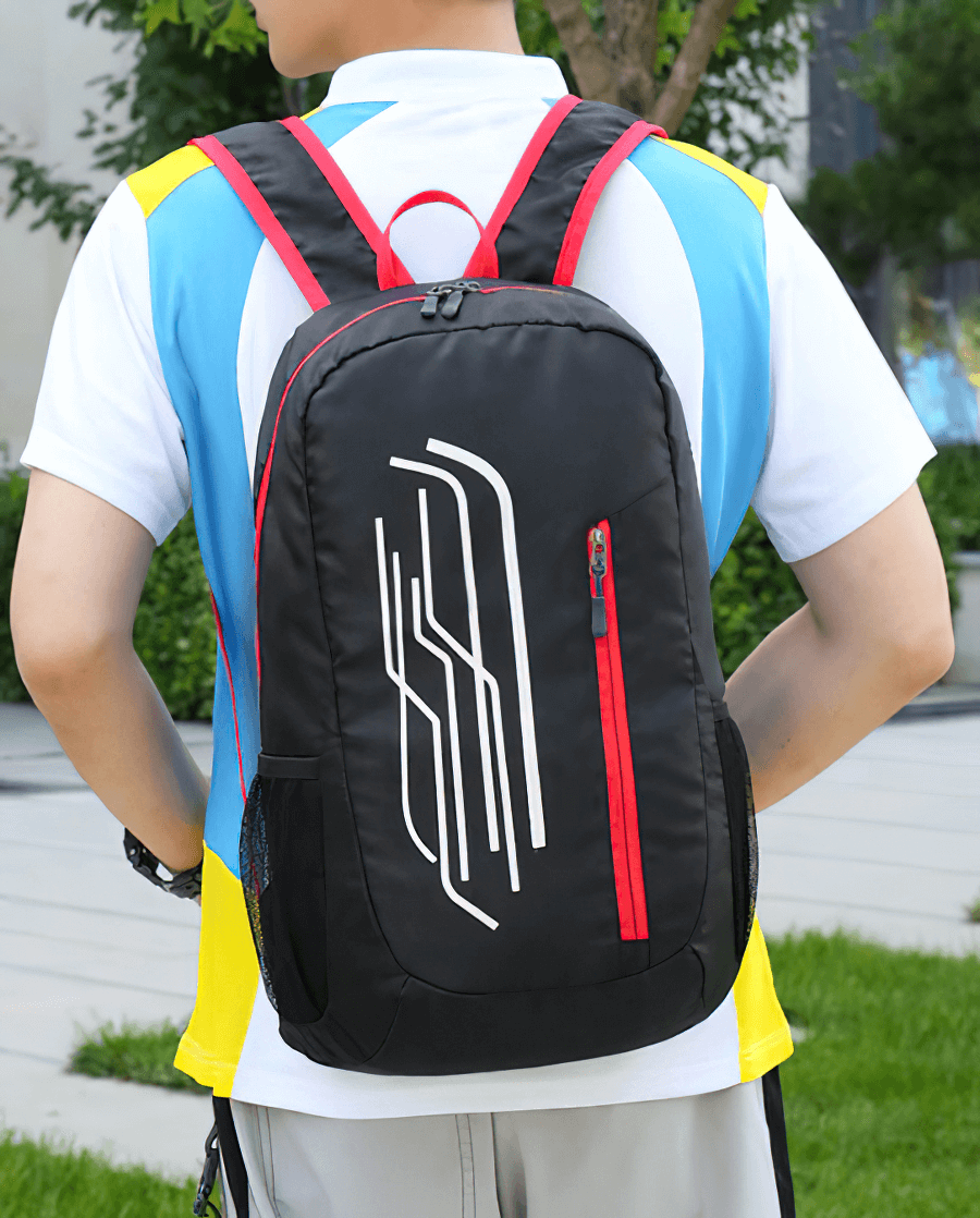 Person wearing a black folding cycling backpack with red accents, featuring ultralight design, perfect for outdoor adventures.