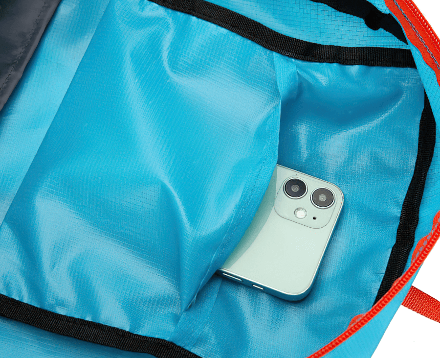 Interior view of a blue 22L cycling backpack with a smartphone neatly stored in its pocket, highlighting its spacious and organized design.