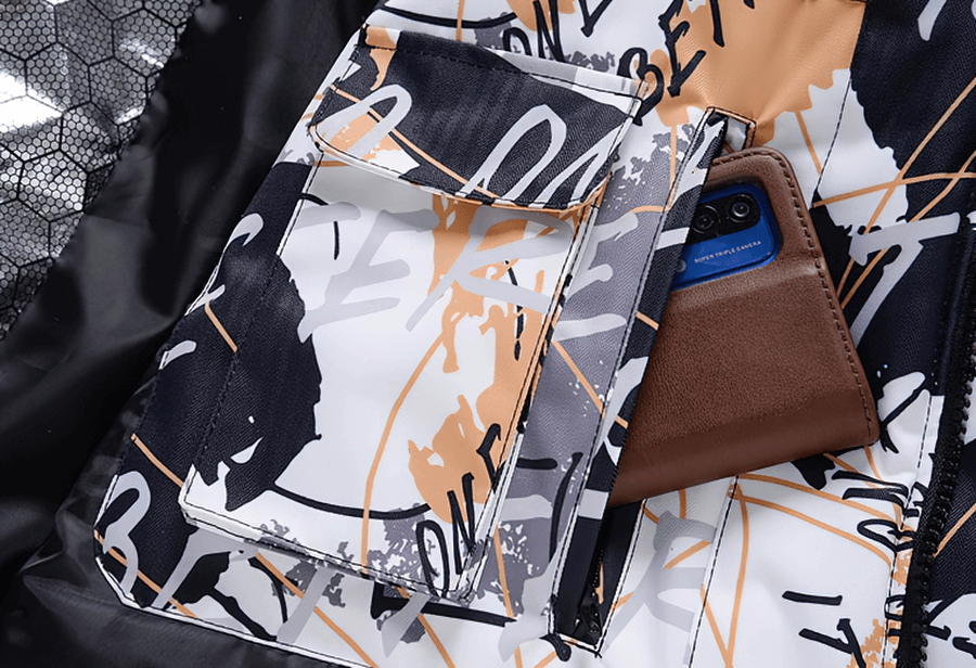 Close-up of colorful patterned waterproof snowboarding jacket pocket with smartphone, showcasing design details.