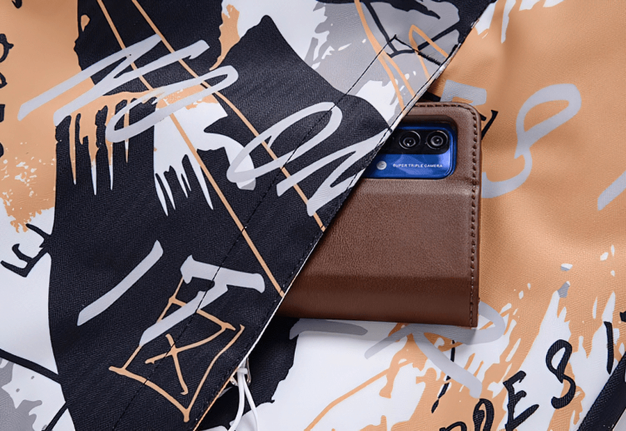 Colorful snowboarding jacket with waterproof fabric and hidden pocket revealing a smartphone, designed for snowy adventures.