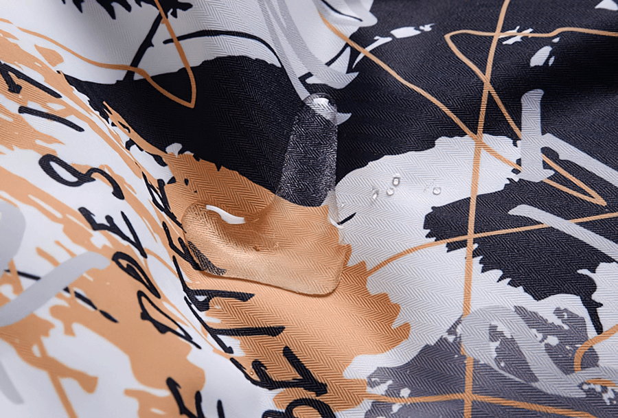 Close-up of colorful textile pattern on a waterproof men's snowboarding jacket, showing vibrant design and durable fabric.