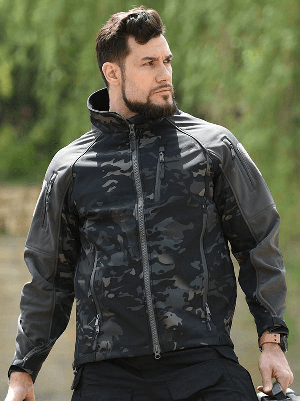 Man wearing adjustable cuffs velcro softshell hiking jacket, windproof and waterproof, ideal for outdoor adventures.