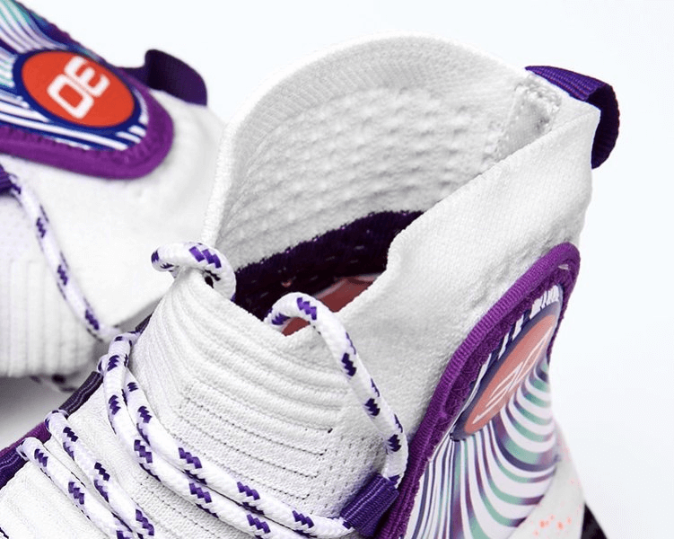 Close-up of breathable basketball sneakers with purple accents and anti-slip rubber sole, designed for optimal sports performance.