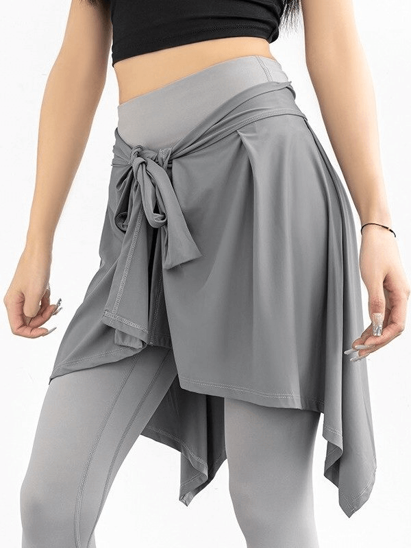 Asymmetric quick-drying women's tennis skirt with ties in solid gray polyester for sporty comfort.