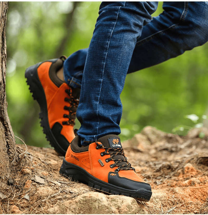 Hiking in style with orange non-slip waterproof boots on a rugged trail, showcasing outdoor trekking performance.