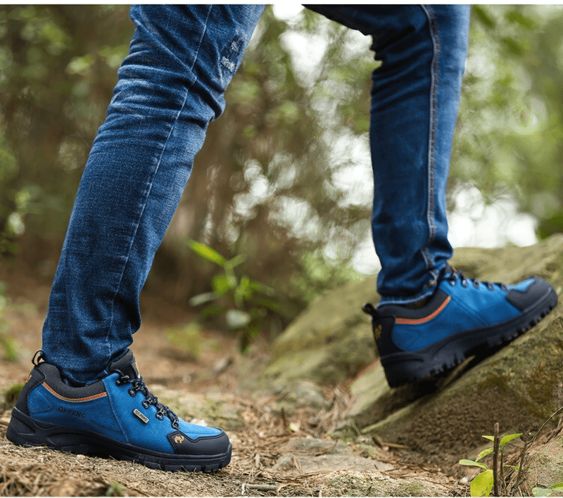Outdoor adventurer wearing blue athletic waterproof hiking shoes on a rugged trail, showcasing non-slip and durable design.