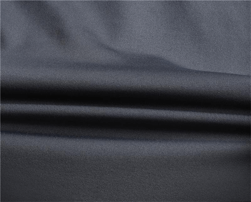 Close-up of gray-black polyester fabric used in quick-drying compression sports leggings, tailored for running and fitness.