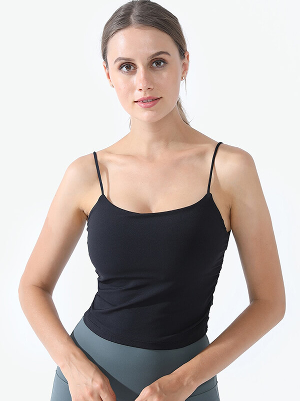 Woman wearing black athletic strap thin camis, perfect for yoga, made from anti-friction nylon for comfort and movement.