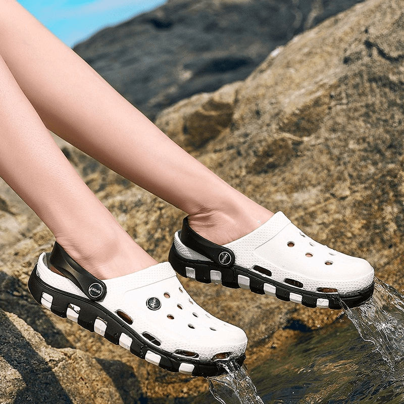 Beach Lightweight Quick-Drying Sandals in white with black soles, showcasing flexible design on rocks. Perfect for beach adventures.
