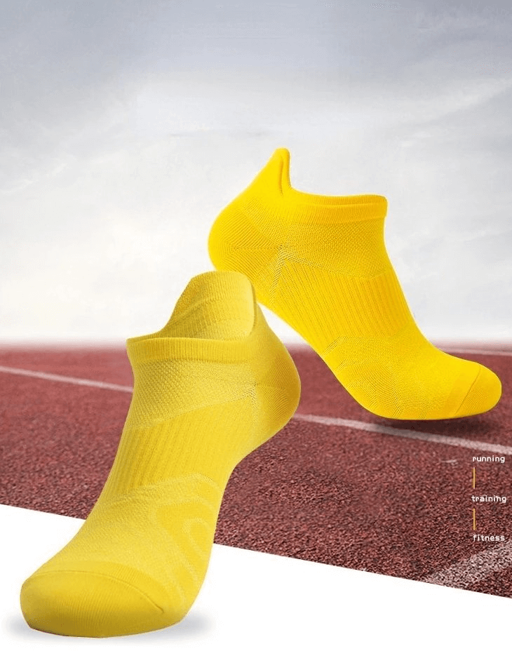 Bright yellow breathable anti-slip sports socks on a running track, ideal for unisex sports use, showcasing lightweight design.