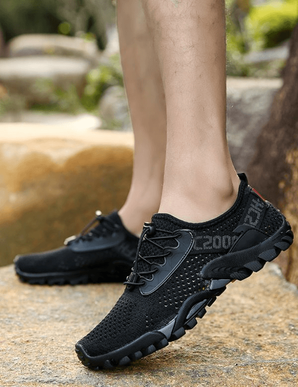 Breathable Elastic Camping Shoes, Men's Sports Sneakers - Black, showing mesh upper and durable rubber outsole in outdoor setting.