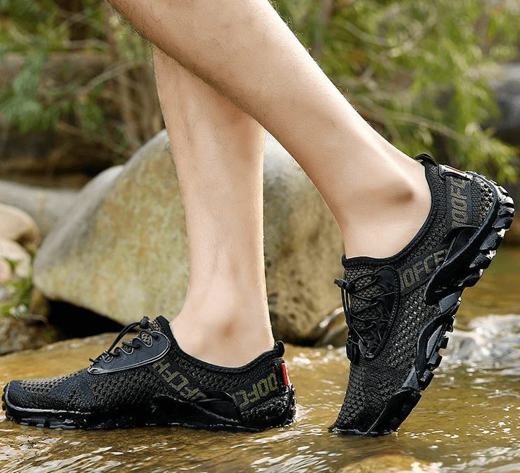 Breathable elastic men's sports sneakers in action near a stream, featuring a durable rubber outsole and comfortable EVA insole for camping.