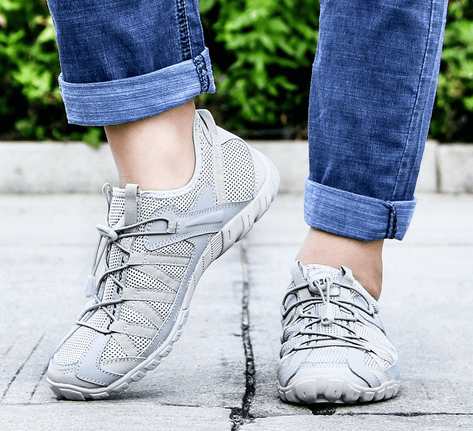 Person wearing breathable mesh flexible sneakers for men on pavement.
