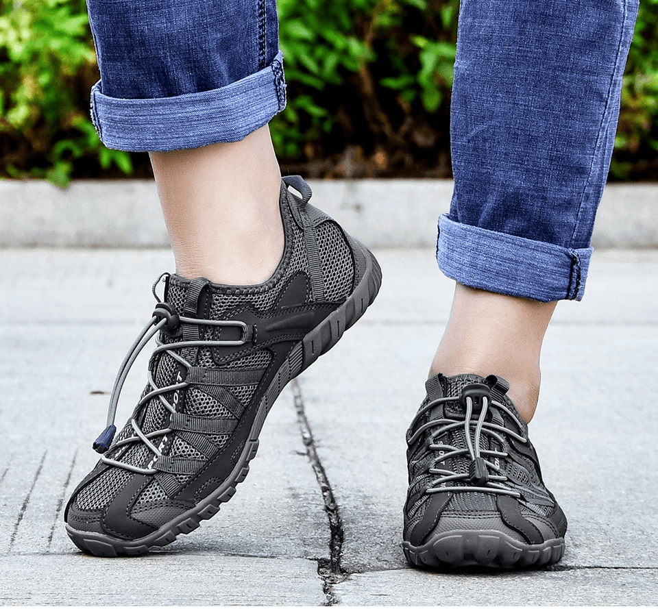 Person wearing breathable mesh flexible men's sneakers, lightweight sports footwear, with elastic band closure.