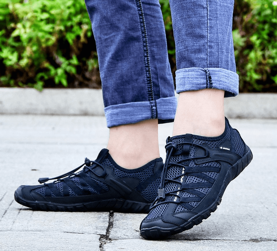 Man wearing breathable mesh flexible sneakers for men, lightweight sports footwear, SF0758, in a casual outdoor setting.